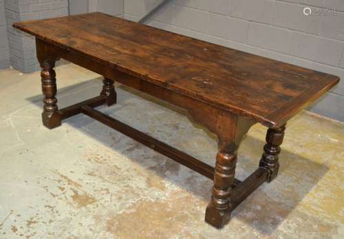 An oak refectory table with a five plank top above heavily turned legs united by an H-form stretcher frame, height 77cm, length 208cm and width 80cm.