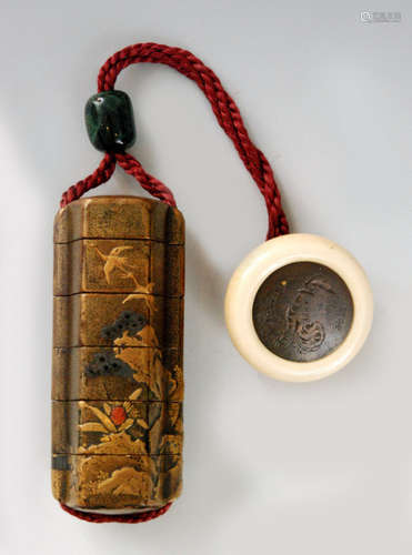 An 18th Century five case inro, the tall hexagonal body with pronounced cord tunnels decorated in gold and coloured takamaki with cranes flying above a house, rocks and trees detailed with single coral inlay, length 7.6cm with a green marbled glass ojime and a kagamibuta ivory cup netsuke, the metal disk engraved with a tiger and bamboo signed Chikaraku, diameter 3.8cm.   BR 077/13