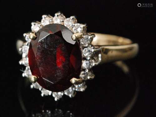 A 9ct garnet and diamond dress ring, oval cut garnet within a brilliant cut diamond surround, ring size N