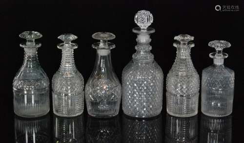 A group of six early 19th Century Regency clear crystal glass decanters comprising a diamond cut Prussian form decanter, two examples with basal cutting, a cylinder form example and a pair with ladder cut necks, tallest 29cm. (6)