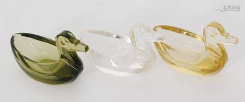 A group of 20h Century Steuben glass salts formed as stylised ducks comprising clear, olive green and citron examples, length 8cm. (3)