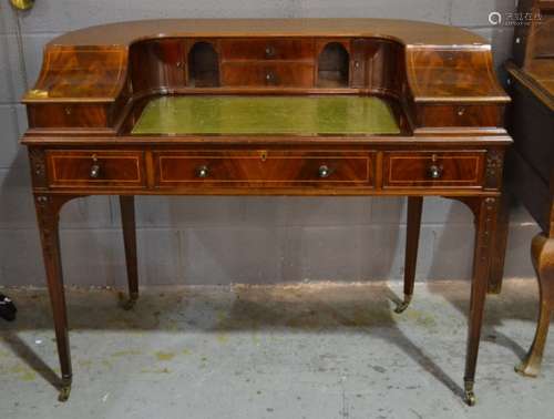 An Edwardian line inlaid mahogany Carlton house desk, the shaped cupboard back with two central drawers over a green leather inset top, three frieze drawers on square tapering legs, width 122cm