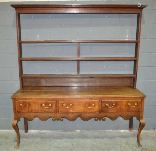 An oak dresser in the Georgian style, with plate rack above three frieze drawers to the shaped apron, with cabriole front legs and block chamfered rear legs, overall height 212cm, width of base 194cm and width of rack 212cm, S/D.