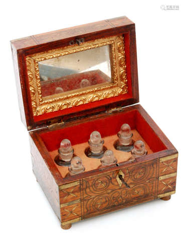 An early 20th Century brass inlaid hardwood scent bottle casket containing six glass bottles, with inset mirror to the lid, width 16cm, a brass trinket box with foliate decoration, width 12cm, a small gilt metal needle case, height 5cm, and a marquetry 'puzzle' box, width 11cm, all probably Indian. (4)