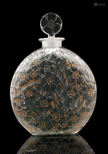 A Rene Lalique Le Lys glass scent bottle bottle, circa 1922, of compressed globe form with relief moulded lilies with cinnamon stained detailing below a circular stopper in the conforming pattern, moulded R LALIQUE mark to base, height 17cm.