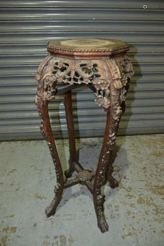 A late 19th Century carved hardwood jardinere stand with octagonal rouge marble inset top on foliate carved legs, 33cm diameter