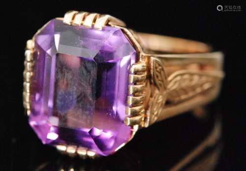 A 9ct hallmarked single stone amethyst ring, emerald cut claw set stone to feathered detailed shoulders, ring size K 1/2, Birmingham 1976, Bernard Instone.