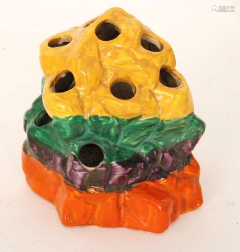 A 1930s Clarice Cliff Liberty Stripe rock form flower frog, hand painted in yellow, green, purple and orange banding, Bizarre mark, height 9.5cm.