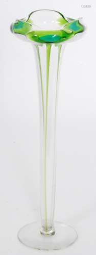 An early 20th Century Stuart & Sons glass vase of footed slender form below a wide trefoil folded rim with applied two tone green peacock trails over the clear crystal ground, unmarked, height 28.5cm.