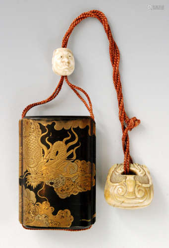 A mid 20th Century four case lacquer inro, the roiro, mirror black ground decorated in gold takamakie and kiribame with a dragon amongst swirling clouds, length 7.8cm, ivory ojime of two conjoined face pulling masks, ivory netsuke carved as a temple bell, S/D.   BR no 077/06