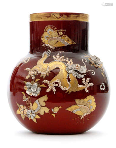 A late 19th Century Harrach glass vase of compressed globe and shaft form decorated in the Aesthetic taste with a dragon below a butterfly and amongst foliage in gilt and relief past enamelling with applied white metal detailing over the red ground and opal interior, unmarked, height 18cm.