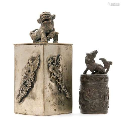 A Chinese silver opium box and cover of square form mounted with a dog of Fo and dragons and birds to the sides and a small cylindrical silver example, both with character stamp marks to the bases (2)