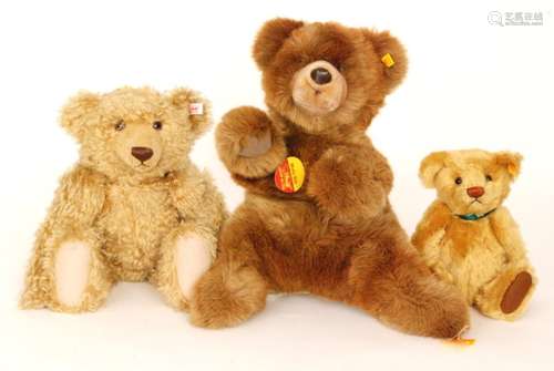 A 20th Century Steiff teddy bear with stitched brown nose and glass eyes, length 43cm , a similar bear with Molly Bar label and a small Steiff bear wearing a Danbury Mint medallion (3)