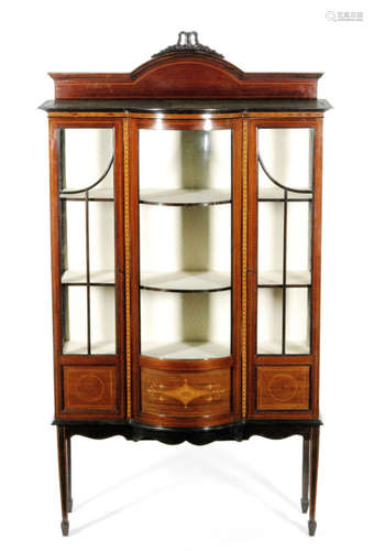 An early 20th Century mahogany Sheraton revival mahogany bow fronted salon side display cabinet, with line inlaid detail and marquetry inlaid borders, the upright pediment section above the bow shaped central glazed panel, flanked by a glazed door at either side, above a shaped apron and square tapered legs with spade feet, height 204cm and width 116cm, S/D.