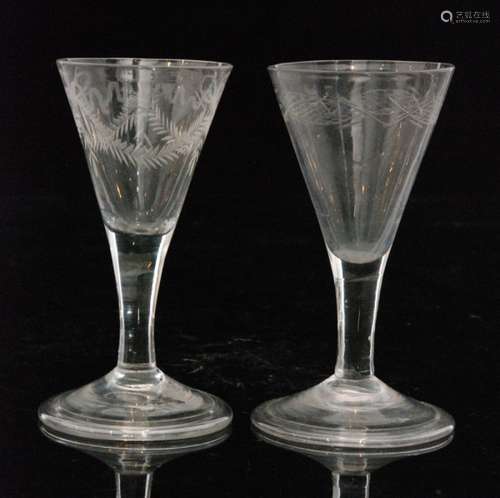 An 18th Century wine or gin glass circa 1740, funnel bowl engraved with flowers below a garland rim above a plain stem, raised to a folded conical foot, height 11cm, together with a similar example. (2)