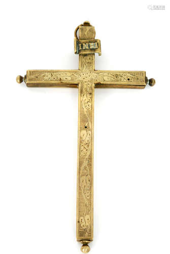 A 19th Century brass reliquary cross opening to reveal fragments of bones of the Saints and Martyrs, the cover with engraved decoration and Inri scroll mounted to the top, length 29cm