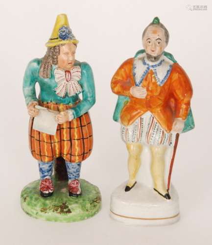 Two 19th Century Staffordshire theatrical figures, the first modelled as a gentleman dressed in an orange bodice with patterned breaches with a green cape and holding a walking cane, height 17.5cm, the second a hunched figure wearing a yellow pointed hat reading from a scroll, height 18cm, S/D. (2)