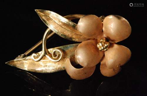 An 18ct hallmarked brooch modelled as a matt finish single flower head to a double leaf stem with scroll detail, length 4cm, weight 6.2g, Birmingham 1962, Bernard Instone.