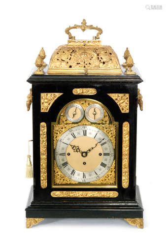 A late 19th Century ebonised and gilt metal mounted bracket clock, the pierced caddy top decorated with angelic figures centred by a mask, twin fusee movement with chime/silent subsidiary dials and Cambridge chimes and chiming on eight graduated bells, silvered chapter ring enclosed by an arched glazed door, engraved back plate on stepped bracket plinth base, height 56cm