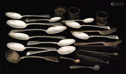 A parcel lot of assorted Georgian and later hallmarked silver flatware to include table and dessert spoons, tongs, sauce ladle etc and three napkin rings, total weight 28.5oz, various styles and dates.