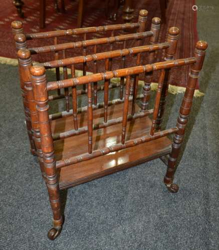 A Victorian mahogany four division Canterbury, with turned supports and raised to porcelain castors, width 40cm.