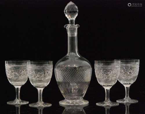 An early 20th Century Stourbridge glass decanter of footed globe and shaft form decorated with a diamond cut band below a slice cut neck and lapidary stopper, height 33cm, together with four clear crystal wine glasses decorated with a band of star cut motives raised on a faceted stem and spread foot, height 14cm. (5)