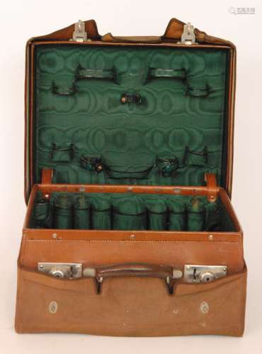 An Edwardian stitched leather gentleman's dressing case with divisioned interior but lacking all bottles in canvas outer case, width 40cm