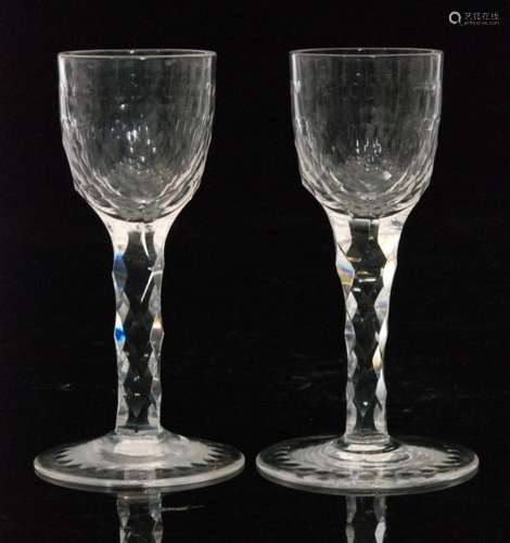 A pair of 19th Century clear crystal drinking glasses, the conical foot below a facet stem and part faceted bowl with a band of printie cuts, unmarked, height 12.5cm. (2)