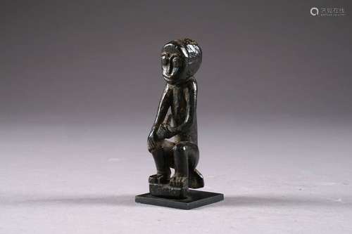 Statuette Kongo. Figurant un personnage assis. Bois sculpté à patine sombre et luxuriante. République démocratique du Congo. Hauteur: 11,5 cm. Sur socle.