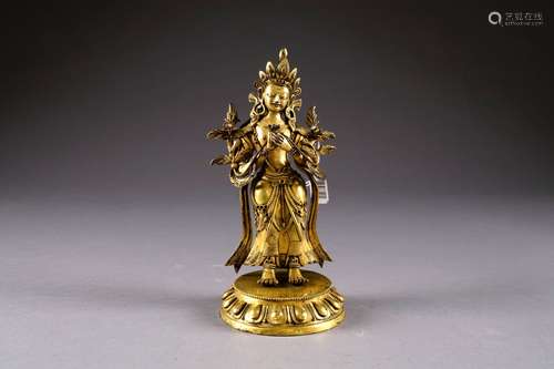 Tara représentée debout. Manches drapées, un bouquet de lotus dans chaque main. Elle est coiffée d'un chignon retenu par un diadème. Socle amovible orné d'un rang de pétales de lotus. Bronze doré. Tibet. XIXe/XXe siècle. Hauteur: 25 cm.