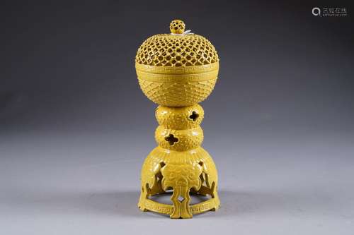 Brûle-Parfum, sphérique. Au couvercle ajouré. Porté par une monture découpée ornée de cinq taoties. Porcelaine de Chine à émail jaune. Marque apocryphe de Kien-Long. Hauteur: 31 cm. Condition: Pas d'accident ni de restauration.