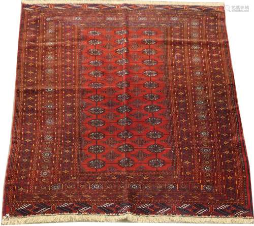 Carpette Bokhara. A triple rang de médaillons. Fond rouge et large bordure cadre. Dimensions: 186 x 123 cm.