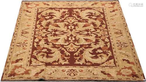 Tapis Ziegler. Grands enroulements feuillés, sur fond rouge. Large bordure claire. Dimensions: 294 x 240 cm.