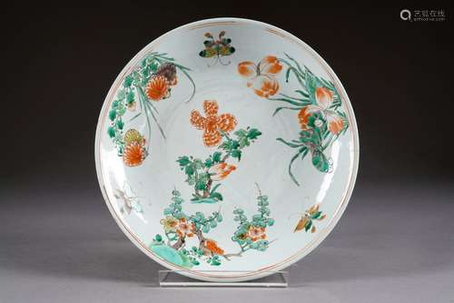 Plat rond. Epoque Kang-Hi (1662-1722). Porcelaine de Chine de la Famille Verte décorée, en plein, de deux papillons parmi quatre plantes aux fleurs épanouies. Marque à la feuille d'armoise dans un double cercle concentrique. Condition: Petites égrenures sur la lèvre et un cheveu d'environ 7 cm. Diamètre: 33,5 cm.