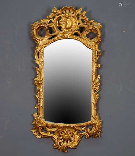 Miroir de Style Louis XV. Encadrement ajouré et sculpté de rocailles. Bois doré. Dimensions: 115 x 54 cm.