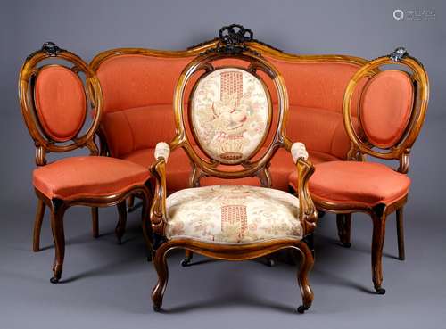 Salon Napoléon III. Il se compose d'un canapé, de six chaises et de sa paire de fauteuils. Dossiers médaillon rehaussés d'un ruban noué. Pieds cambrés à gorges et moulures. Palissandre. Travail de la fin du XIXe siècle.