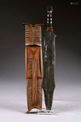 Glaive Salampasu. Lame découpée et prise en bois sculpté. Fourreau en cuir patiné et vannerie. Kasaï. République démocratique du Congo. Longueur: 58 cm.