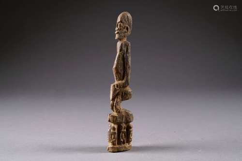 Statuette Dogon. Figurant un homme assis sur un socle formé de six personnages. Bois sculpté et patiné. Mali. Hauteur: 28 cm.