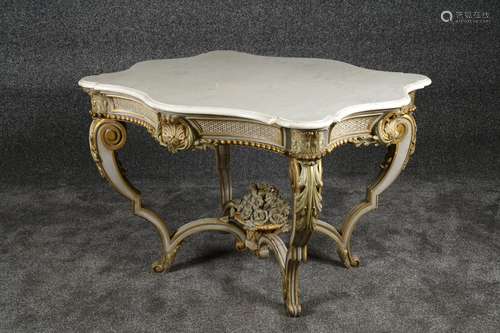 Table de Milieu de Style Louis XV. Sommée d’un marbre blanc. Ceinture fortement mouvementée et sculptée de coquilles. Pieds cambrés réunis par une entretoise rehaussée d’un panier fleuri. Bois laqué gris et or. Travail de la fin du XIXe siècle. Dimensions:75 x 113 x 97 cm.