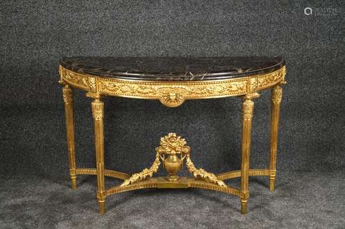 Console. De forme demi-lune et sommée d'un marbre mouluré. Ceinture sculptée de feuilles et pieds cannelés. Bois doré. Travail actuel de style Louis XVI. Dimensions:<br/>85 x 134 x 55 cm.