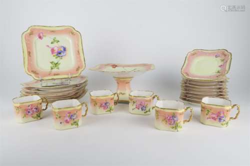 Service à dessert en porcelaine à décor floral, comprenant un présentoir, six assiettes, six tasses et neuf sous tasses.