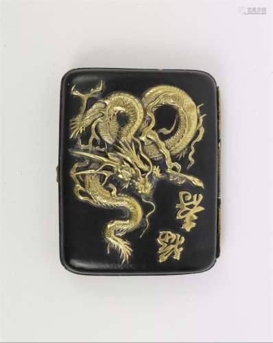 Etui à cigarettes en laiton partiellement laqué noir à décor en relief d'un dragon et d'idéogrammes, l'intérieur argenté.
