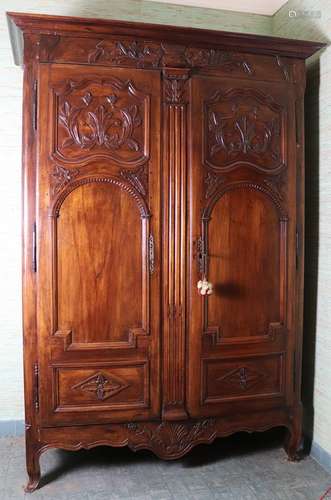 Grande et belle armoire en bois fruitier mouluré et sculpté, ouvrant à deux portes.