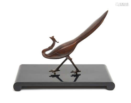 A stylised bronze phoenix-bird on a black lacquered plinth in a box