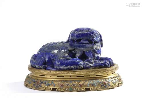 A Chinese lapis lazuli carving of a Buddhist lion on a gilt bronze champlevé enamel stand