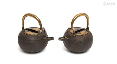 A set of two iron sake kettles with a silver lined sprout