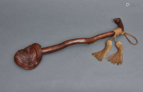 A long plain wooden nyoi-sceptre with a faded brown cord
