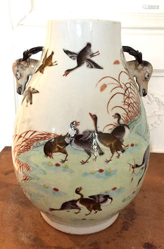 CHINE<br>Vase ovoide en porcelaine polychrome émaillée à décor de canards, les prises à têtes de faons stylisés. Percé sous la base. Marque apocryphe de Qianlong.<br>XIXème siècle<br>Haut : 29 cm<br>quelques éclats sur les cornes, légère égrenure sur le col<br> <br>Expert : Monsieur Vincent L'Herrou <br>