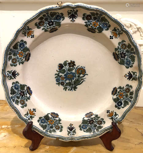 MOUSTIERS Assiette en faience décorée en polychromie de fleurs de solannées. XVIIIème siècle Diam : 25 cm (légers éclats)  Expert : Monsieur L'Herrou