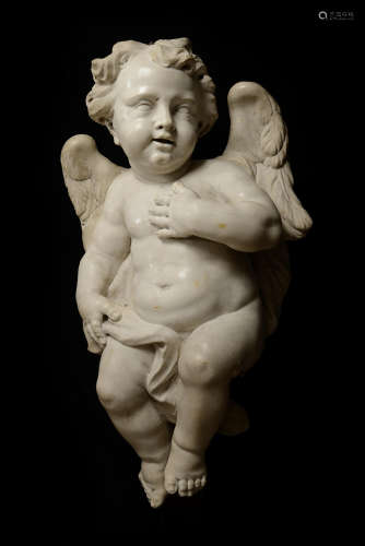 ANGELOT en marbre sculpté, dos plat. Les ailes déployées, il tourne la tête, la main gauche posée sur sa poitrine. Italie, XVIIe siècle Hauteur : 70 cm (une aile cassée et recollée) Soclé  Expert : Cabinet Fligny